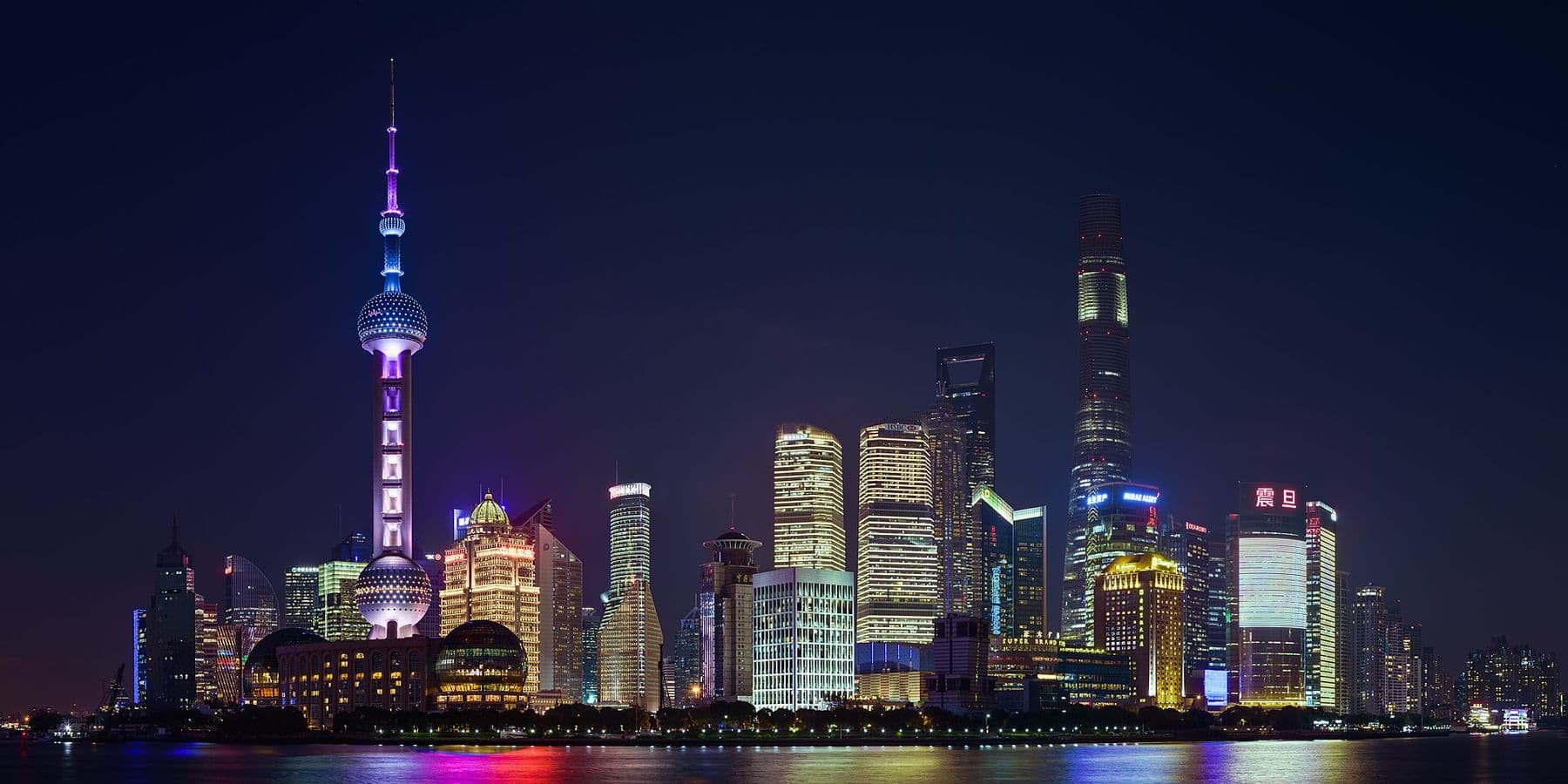 Shanghai's Pudong skyline lit up at night across the Huangpu River